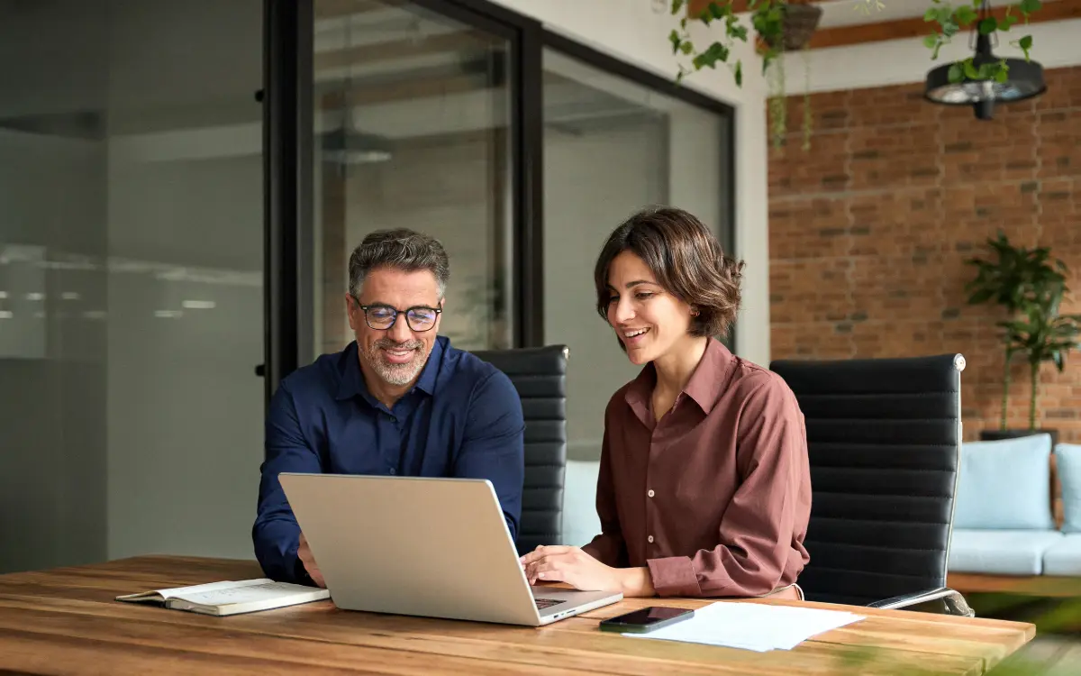 Arquitecto y jefe de obra revisando el certificado final de obra junto a una certificación de avance en la oficina técnica