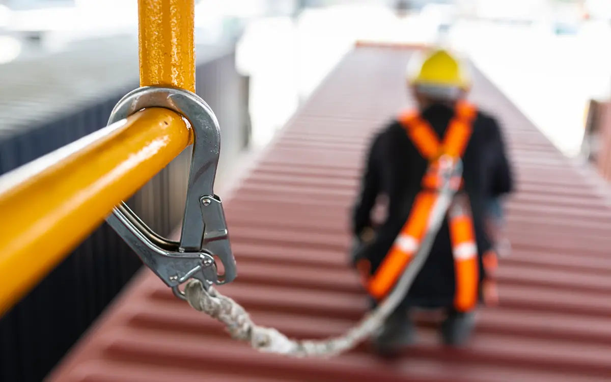 Técnico y jefe de obra revisando el plan de seguridad y salud en obra con planos y cascos de protección