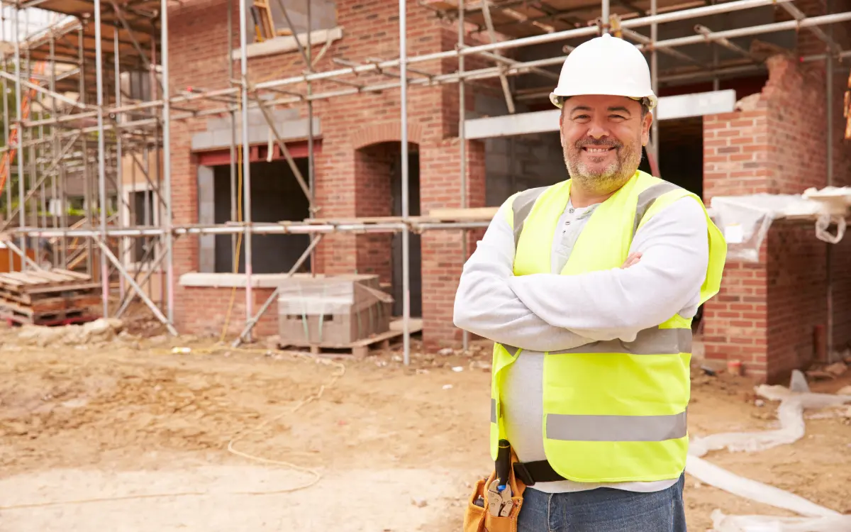 Jefe de obra analizando métricas y gráficos del rendimiento de la mano de obra en construcción desde una tablet